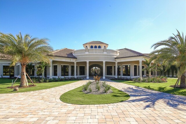 rear view of property with a yard and a balcony