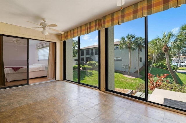 unfurnished sunroom with ceiling fan