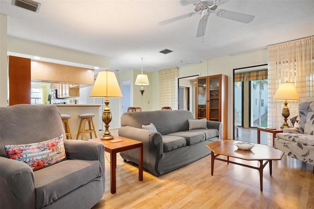 living room with plenty of natural light, light hardwood / wood-style floors, and a textured ceiling