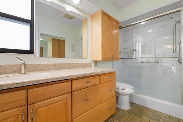 bathroom with vanity, toilet, and an enclosed shower