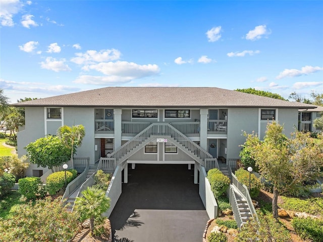 view of property featuring stairway and aphalt driveway