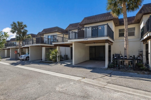 view of front of property featuring a balcony and central AC unit