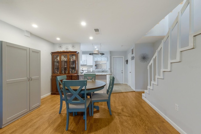 dining space with sink and light hardwood / wood-style flooring