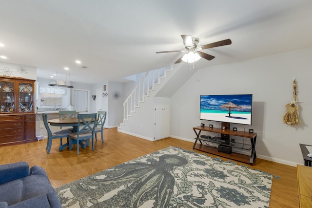 living room featuring ceiling fan, sink, and light wood-type flooring