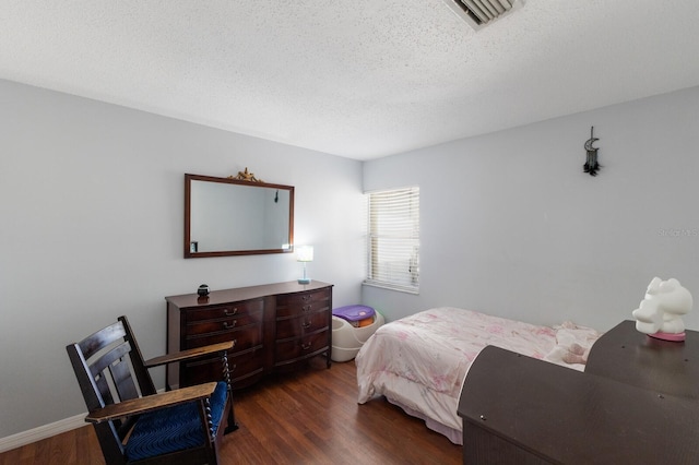 bedroom featuring a textured ceiling and dark hardwood / wood-style flooring