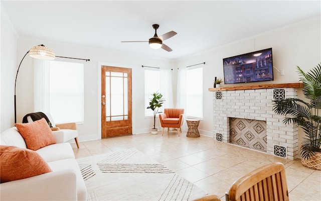 living room featuring ceiling fan, a fireplace, light tile patterned floors, and ornamental molding