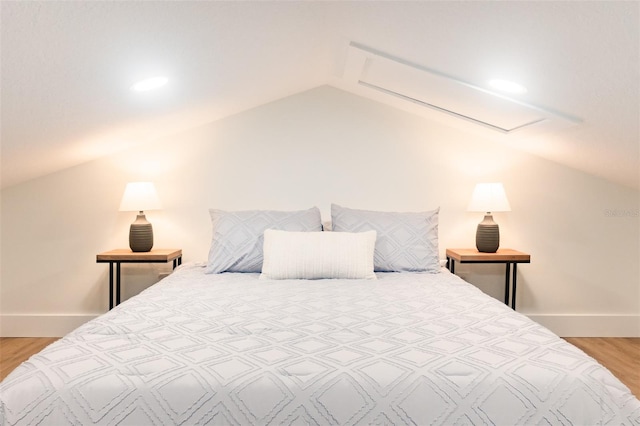 bedroom with light hardwood / wood-style floors and lofted ceiling