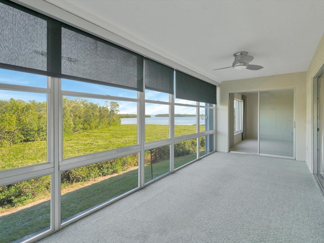 unfurnished sunroom featuring a water view and ceiling fan