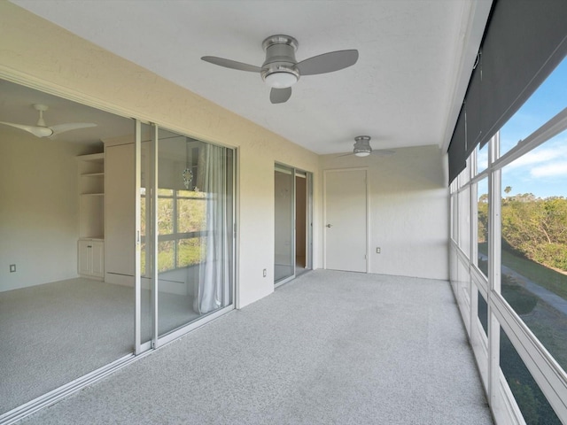 unfurnished sunroom with ceiling fan