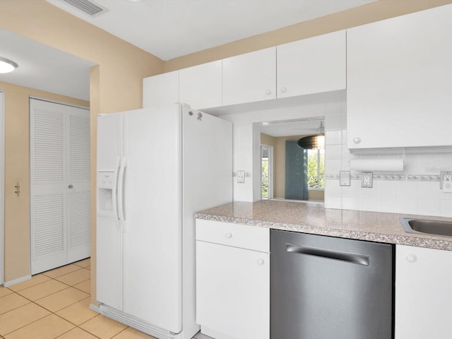 kitchen with backsplash, white cabinets, white refrigerator with ice dispenser, light tile patterned floors, and dishwasher