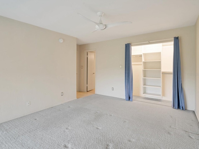 carpeted spare room featuring ceiling fan