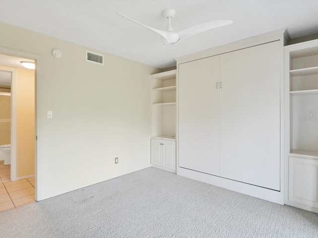 unfurnished bedroom featuring ceiling fan and light carpet