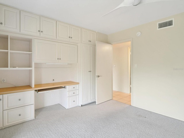 unfurnished office with light colored carpet and built in desk