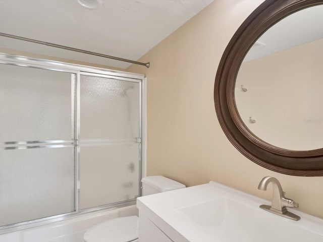 full bathroom with vanity, toilet, and bath / shower combo with glass door