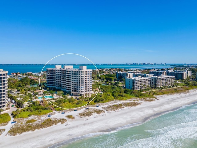 birds eye view of property with a water view and a beach view