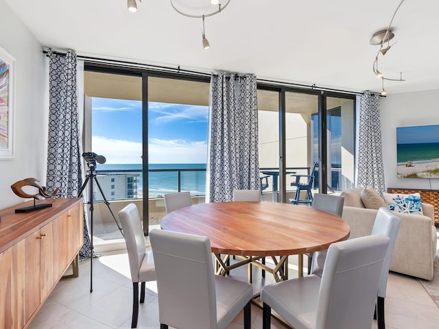 dining space with light tile patterned flooring and a wall of windows