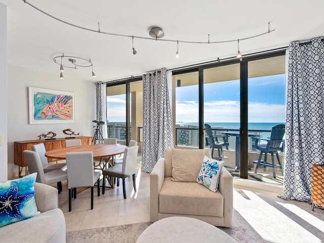 tiled living room featuring a water view and expansive windows