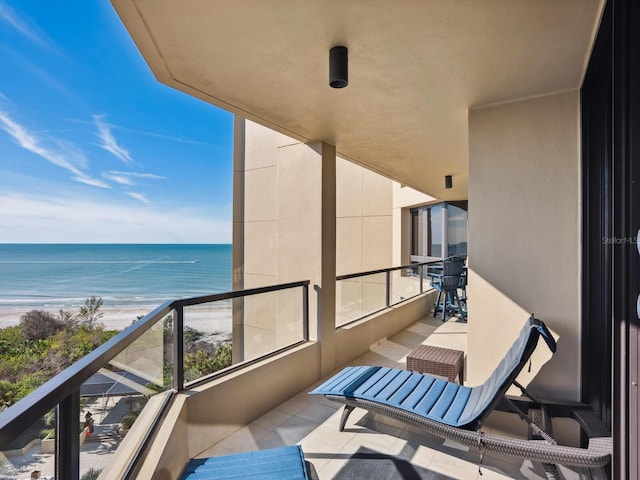 balcony with a water view and a beach view