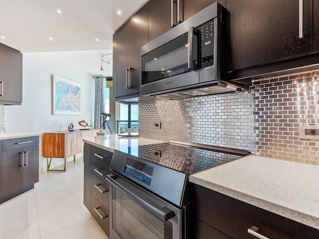 kitchen with decorative backsplash, light tile patterned floors, and stainless steel appliances