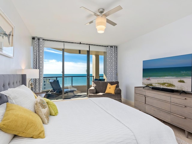 bedroom featuring hardwood / wood-style flooring, ceiling fan, expansive windows, and access to outside