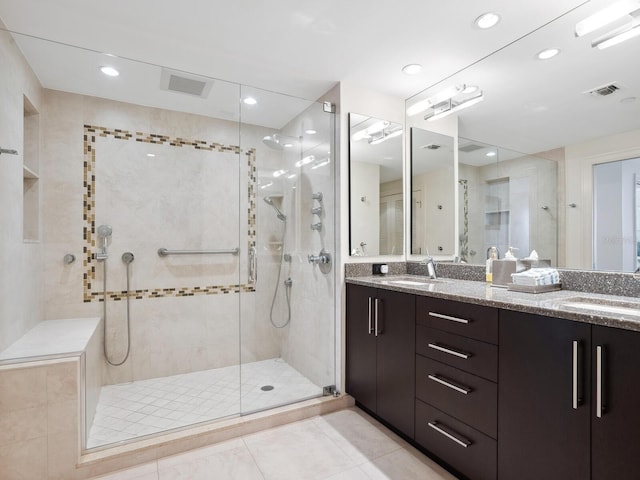 bathroom featuring tile patterned flooring, vanity, and walk in shower