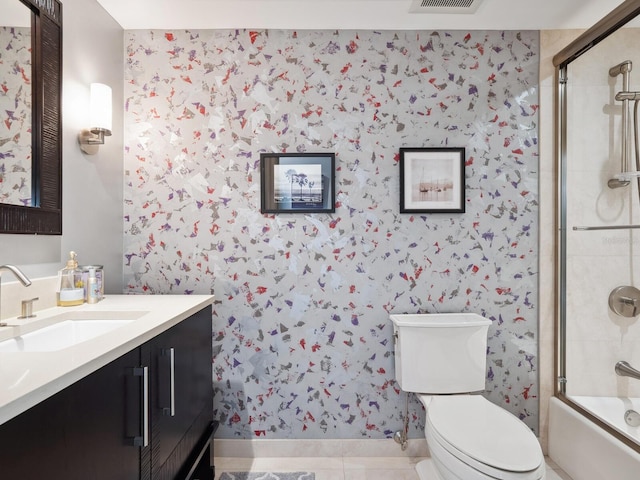 full bathroom featuring tile patterned floors, vanity, toilet, and enclosed tub / shower combo