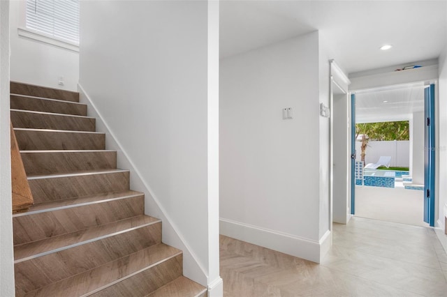 staircase featuring parquet flooring