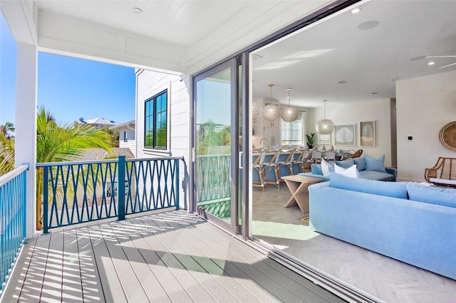 balcony with an outdoor living space and ceiling fan