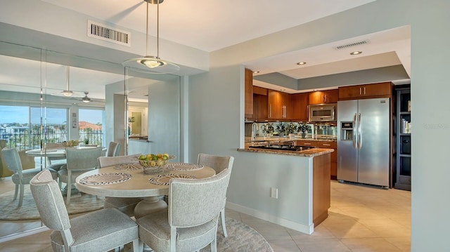 kitchen with kitchen peninsula, appliances with stainless steel finishes, ceiling fan, pendant lighting, and stone countertops