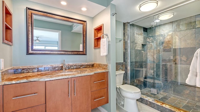 bathroom featuring tile patterned floors, vanity, an enclosed shower, and toilet