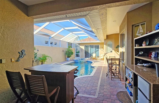 view of pool with a lanai, a patio area, an in ground hot tub, and exterior bar