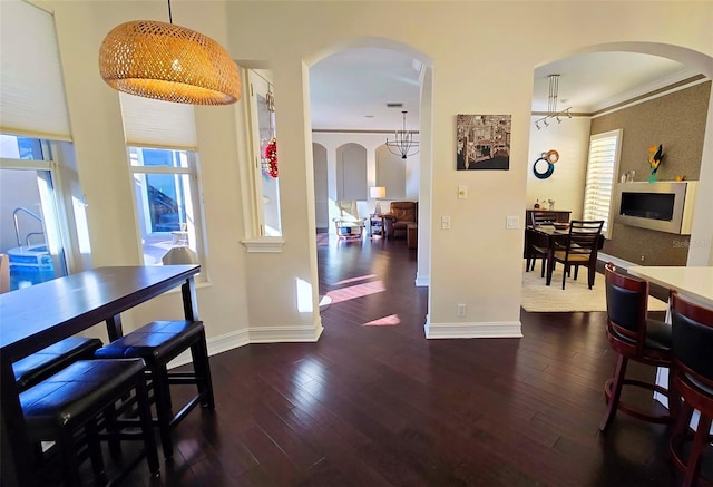 dining room featuring ornamental molding, dark wood-type flooring, and a notable chandelier