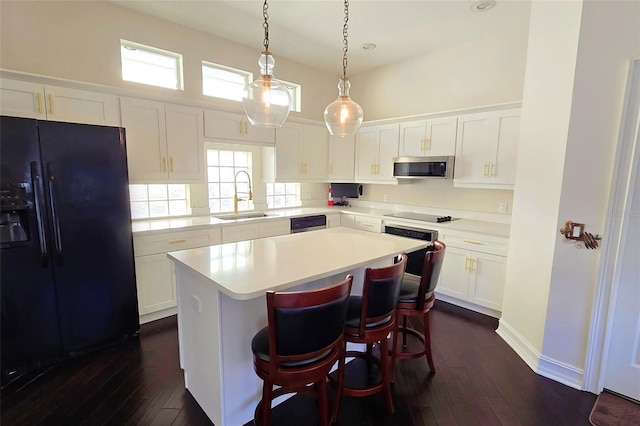 kitchen featuring a center island, dark wood-type flooring, sink, appliances with stainless steel finishes, and white cabinetry