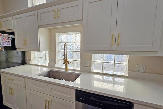 kitchen with white cabinets, stainless steel dishwasher, and sink