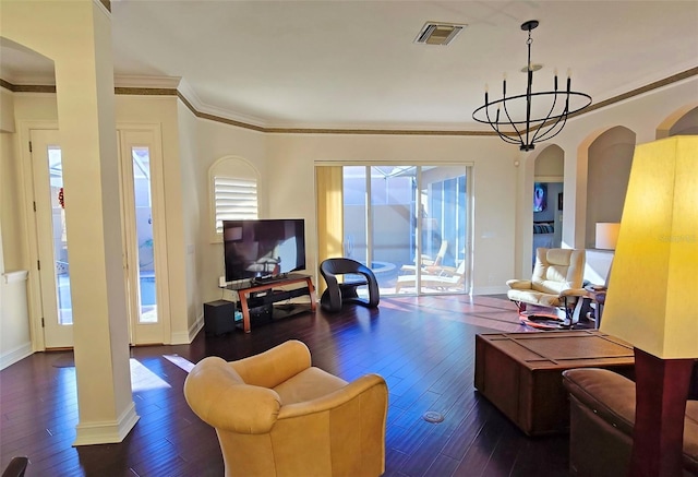 living room featuring a chandelier, dark hardwood / wood-style flooring, and crown molding