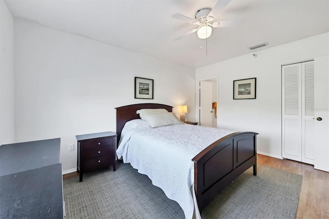 bedroom with ceiling fan, dark hardwood / wood-style flooring, and a closet