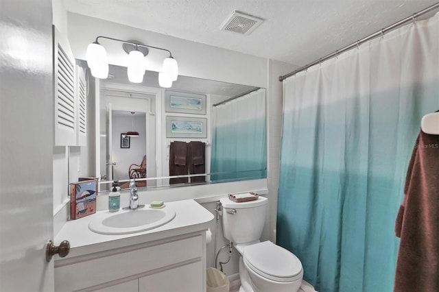 bathroom featuring vanity, a shower with shower curtain, a textured ceiling, and toilet