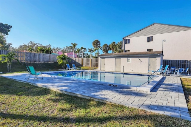 view of pool with a patio area and a yard