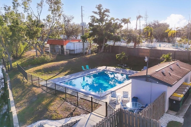 view of swimming pool featuring a shed and a yard