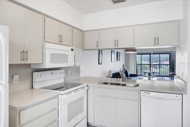 2124 N Tamiami Trl Unit 103, Sarasota, FL 34234 - kitchen with white appliances, a sink, light countertops, and decorative backsplash