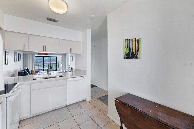 2124 N Tamiami Trl Unit 103, Sarasota, FL 34234 - kitchen with white appliances, a sink, light countertops, white cabinets, and light tile patterned flooring