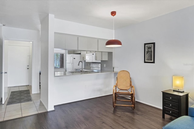 2124 N Tamiami Trl Unit 103, Sarasota, FL 34234 - kitchen featuring white appliances, wood finished floors, a sink, and decorative light fixtures