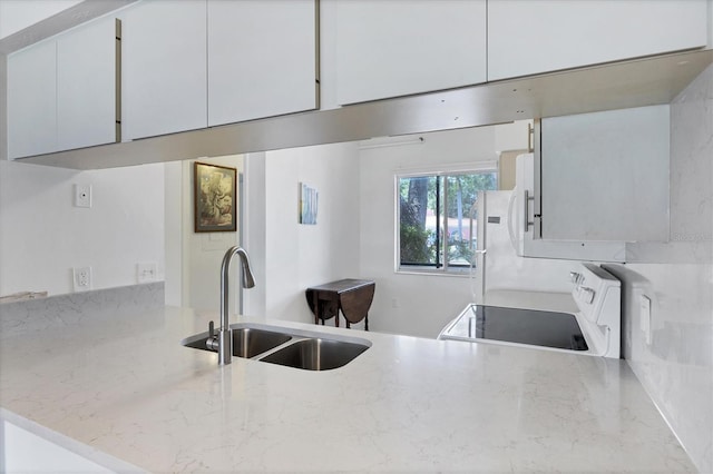 2124 N Tamiami Trl Unit 103, Sarasota, FL 34234 - kitchen with a sink, white appliances, a peninsula, and light stone countertops