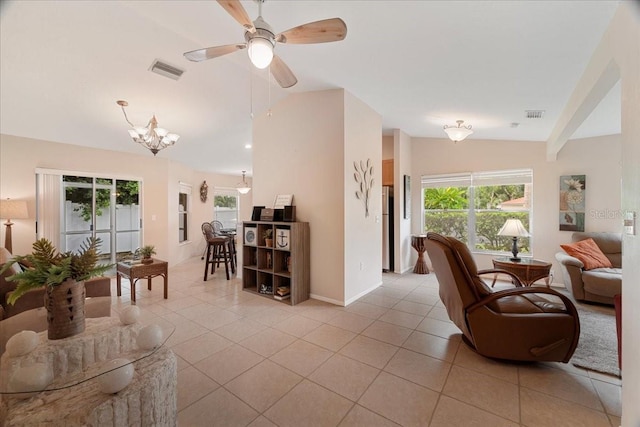 tiled living room featuring ceiling fan with notable chandelier and vaulted ceiling