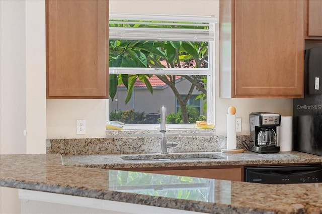 kitchen with dishwasher, light stone counters, a wealth of natural light, and sink