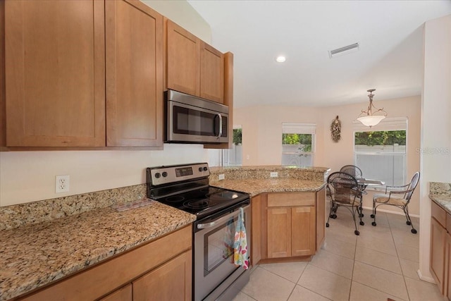 kitchen featuring light stone countertops, appliances with stainless steel finishes, light tile patterned floors, and pendant lighting