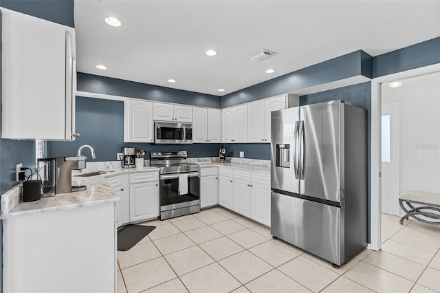 kitchen with light stone countertops, stainless steel appliances, sink, white cabinets, and light tile patterned flooring