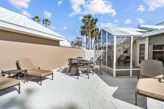 view of patio featuring glass enclosure