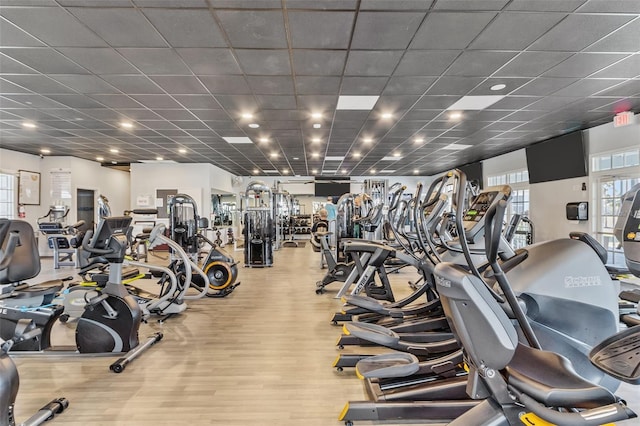 exercise room with a paneled ceiling and light hardwood / wood-style floors