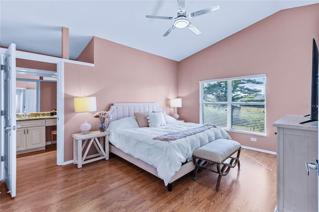 bedroom with hardwood / wood-style floors, ensuite bathroom, vaulted ceiling, and ceiling fan